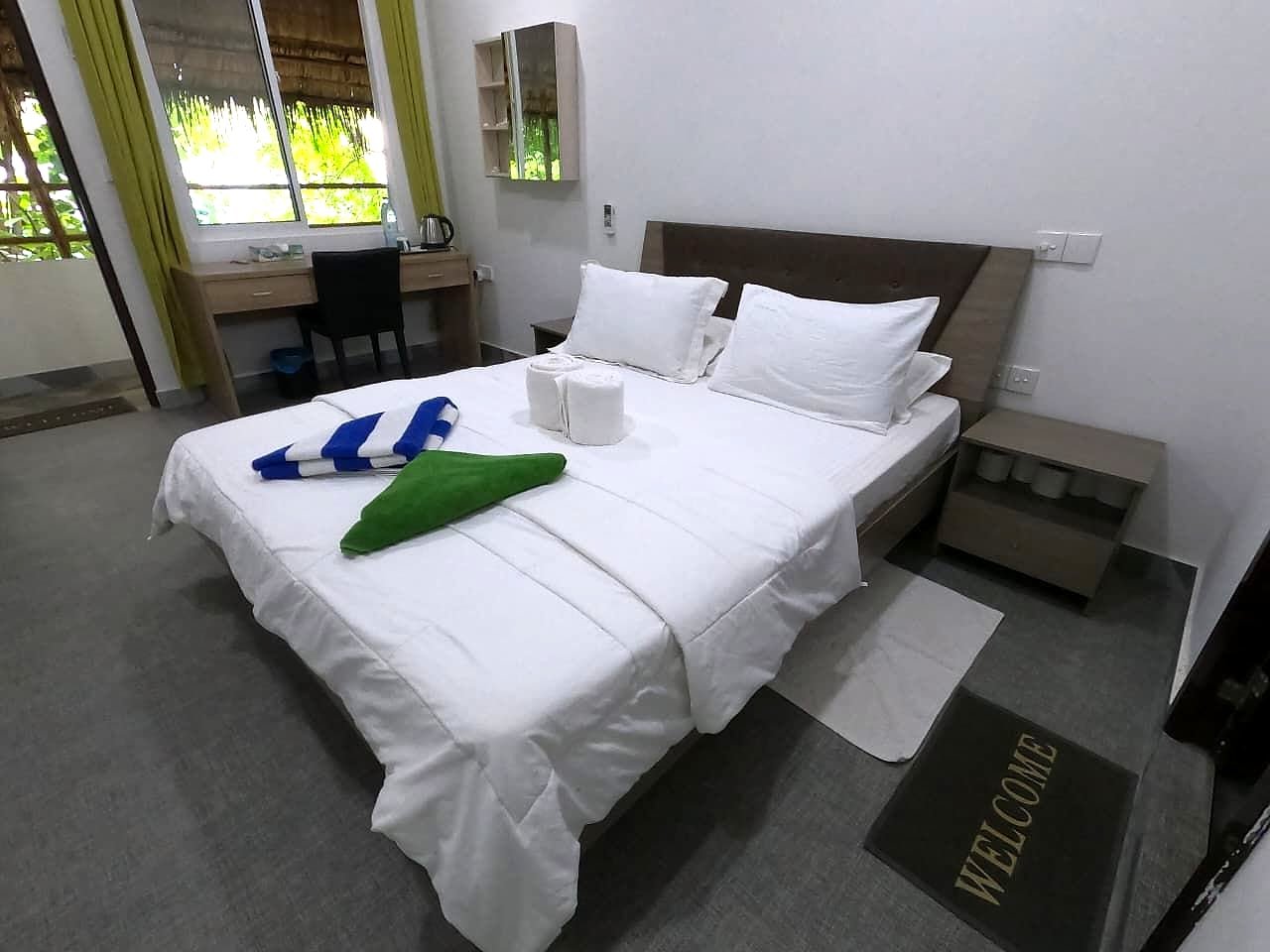 Deluxe Double bed with fresh towels, garden light through the window