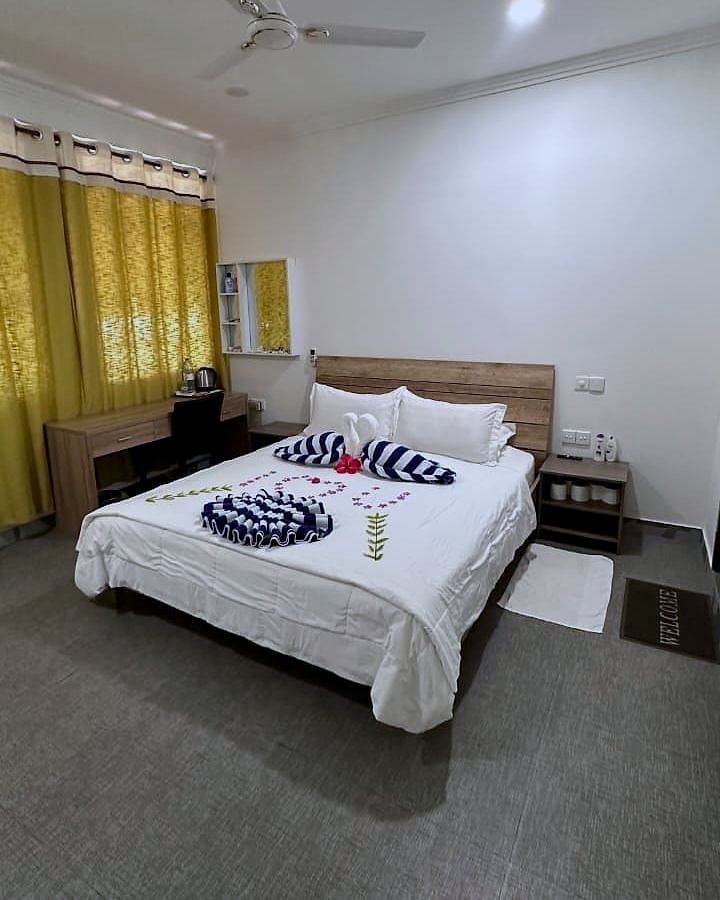 Family Room seen from the doorway — bed, desk and mirror shelf